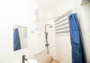 A bathroom with a shower, a toilet, a mirror, and a towel rack. - NK Luxury Hotel DN (Accra)