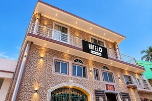 Un hôtel à plusieurs étages, doté d’une façade en pierre, de balcons et d’une enseigne indiquant qu’il est géré par OYO.