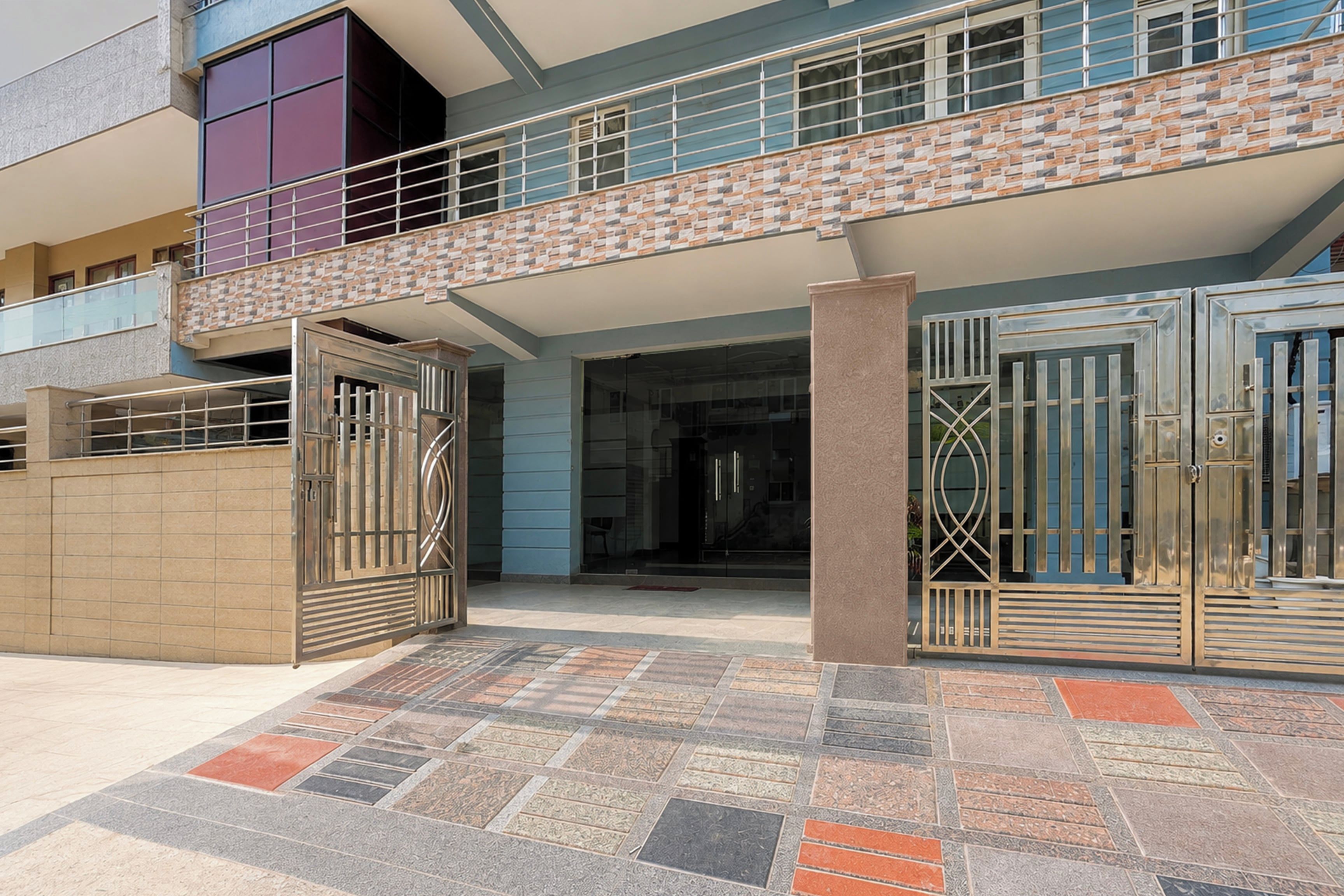 Um edifício moderno com portão fechado, passarela coberta e estrutura de vários andares.