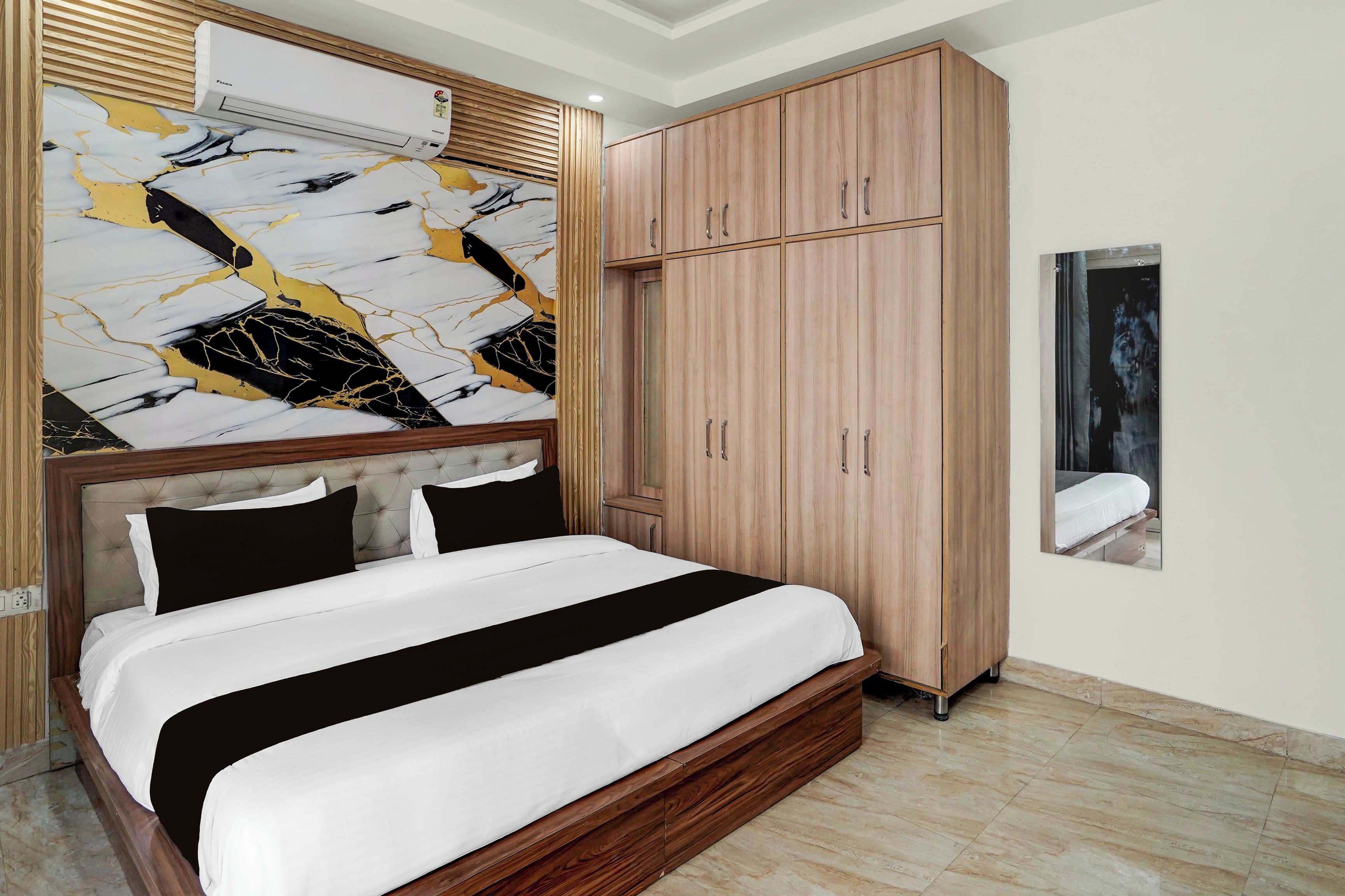 Une chambre à coucher comprenant un lit, une armoire et un climatiseur fixé au mur.