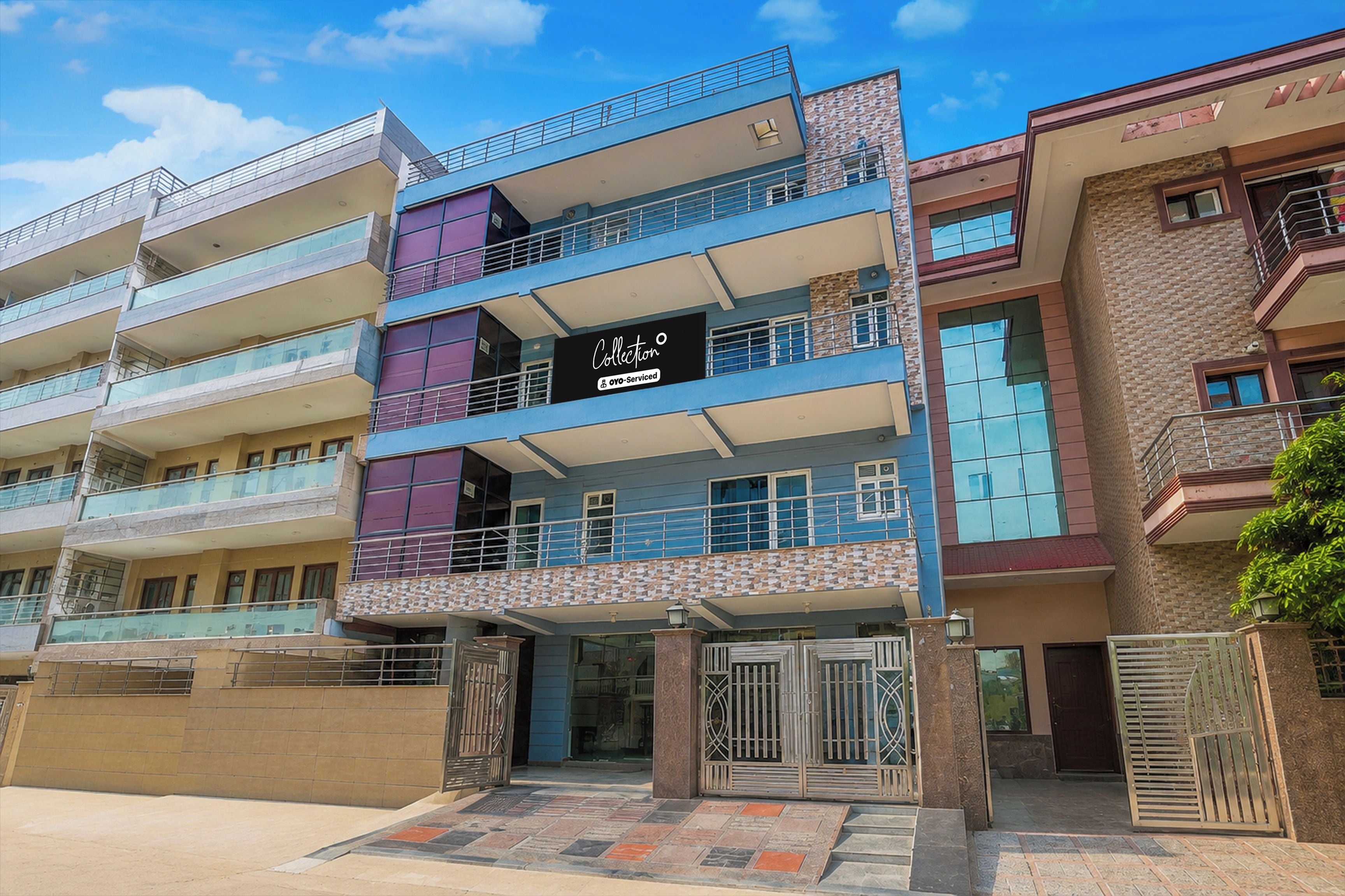 A multi-story building with balconies, a storefront, and a gated entrance.
