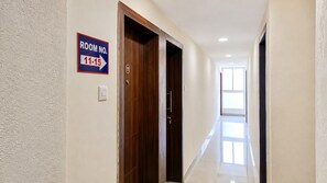 A hotel hallway with a sign indicating room numbers 11-15. - Collection O Phase-I Hinjewadi (Paud)