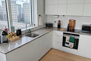 Eine moderne Küche mit Spüle aus Edelstahl, einem Toaster und einem Pizzaofen.