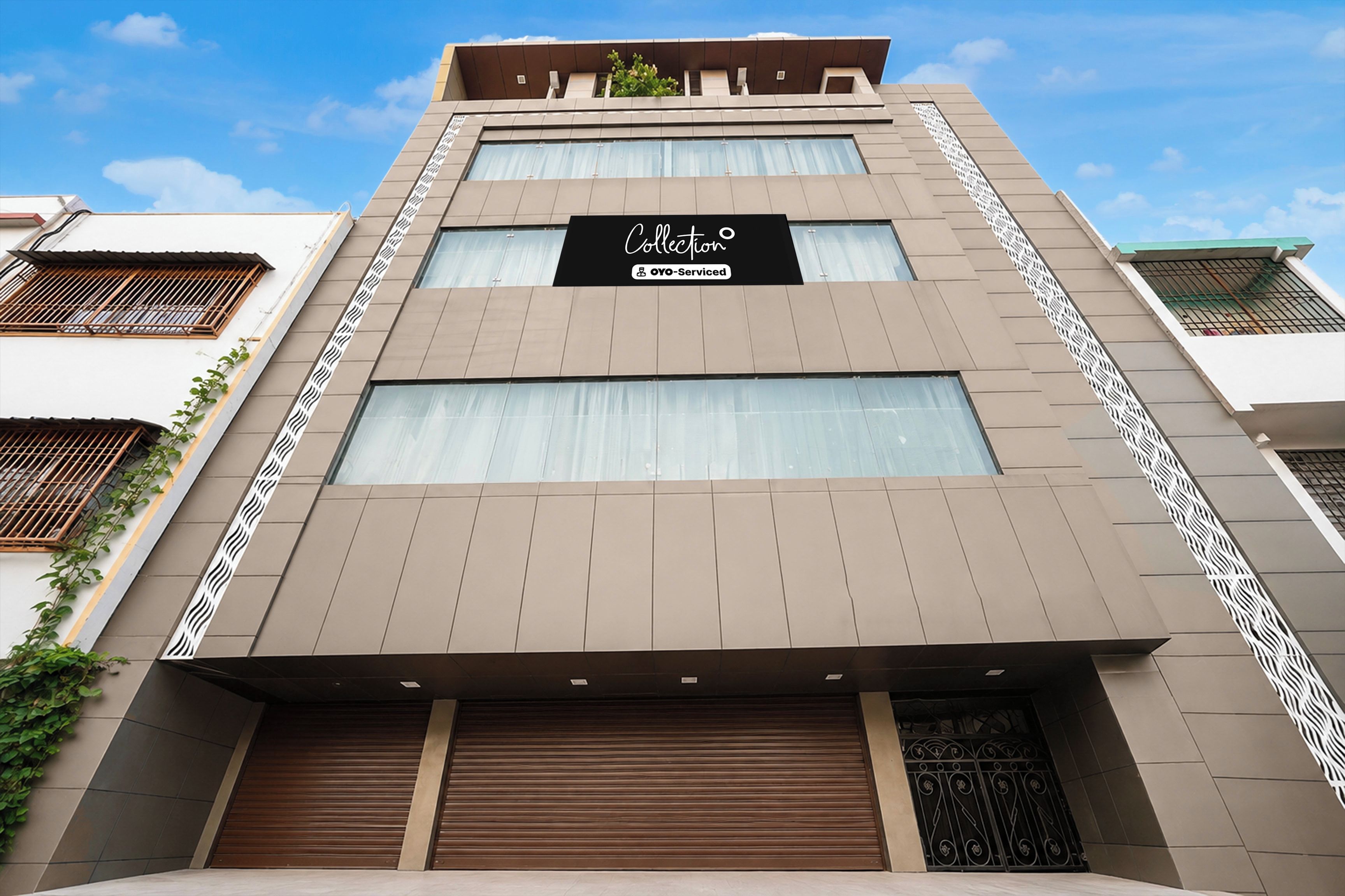 Un edificio moderno con un letrero que dice 'Collection Oyoserviced' en la fachada.
