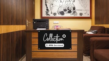 A reception desk with a sign reading 'Collection' and 'OYO-Serviced'.