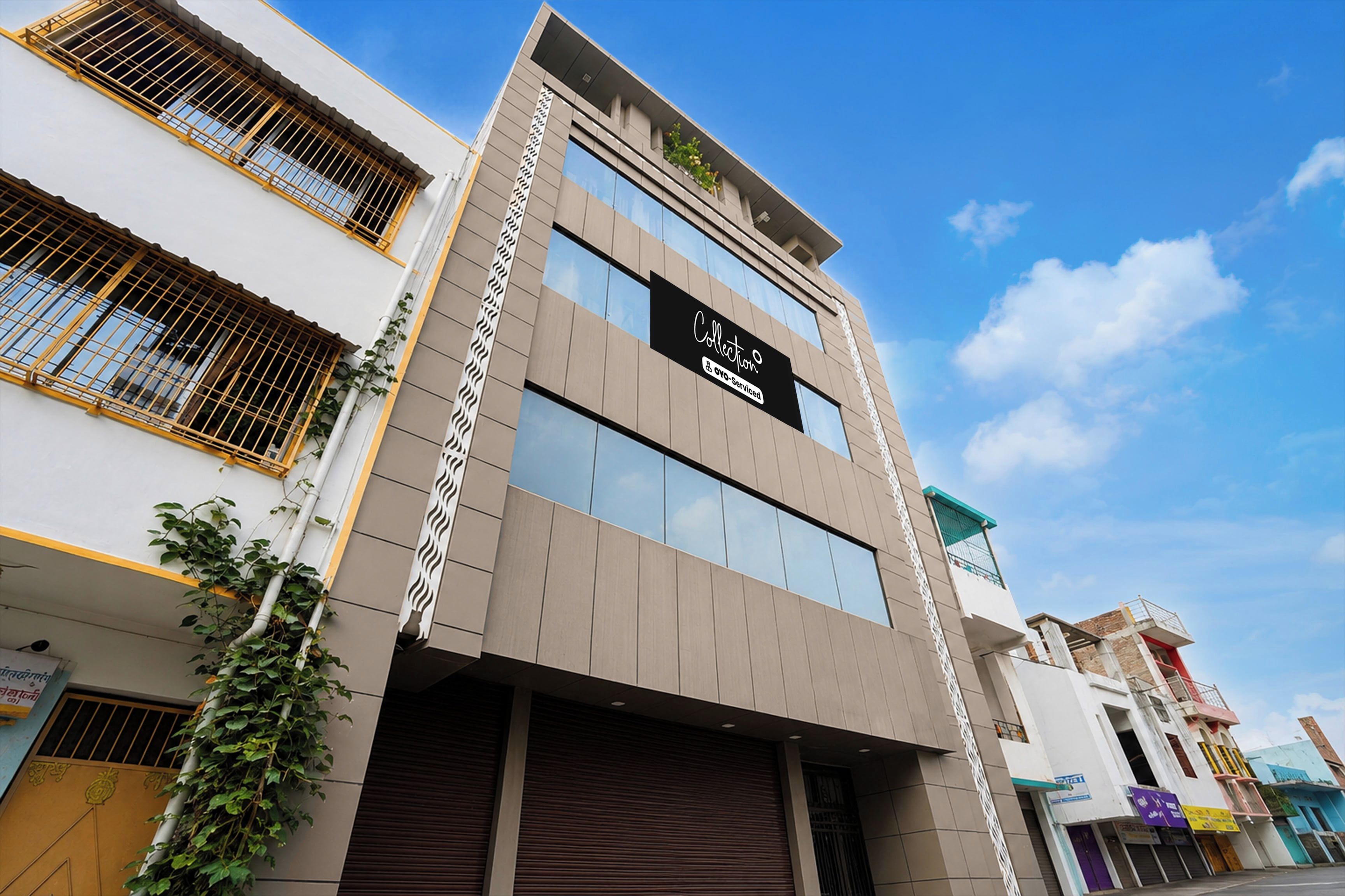 A multi-story building with a modern facade, large windows, and a sign indicating it is serviced by OYO.