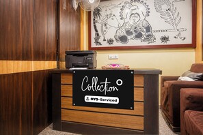 Un comptoir d’accueil avec une pancarte indiquant qu’il est géré par OYO.