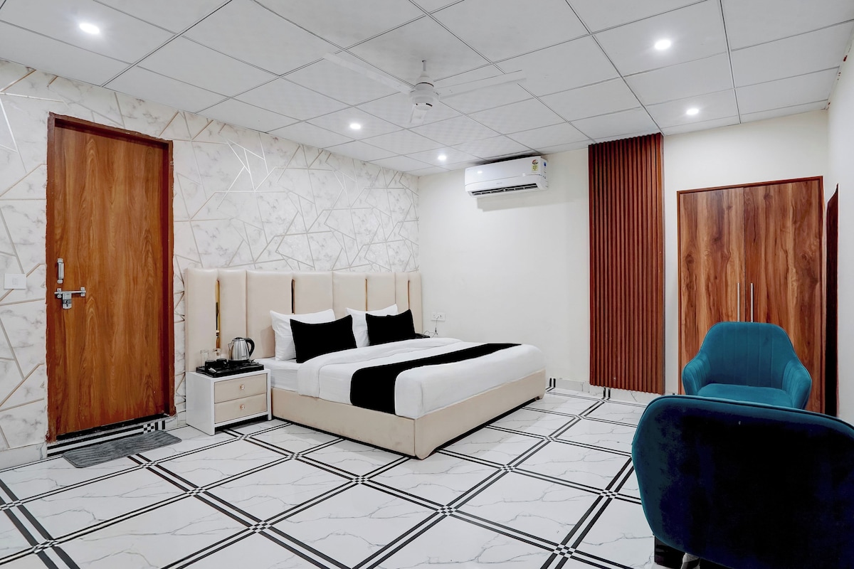 Quarto moderno com cama, mesa de cabeceira e uma cadeira azul.