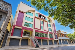 A hotel with a modern facade, multiple windows, and a visible staircase leading to the entrance.