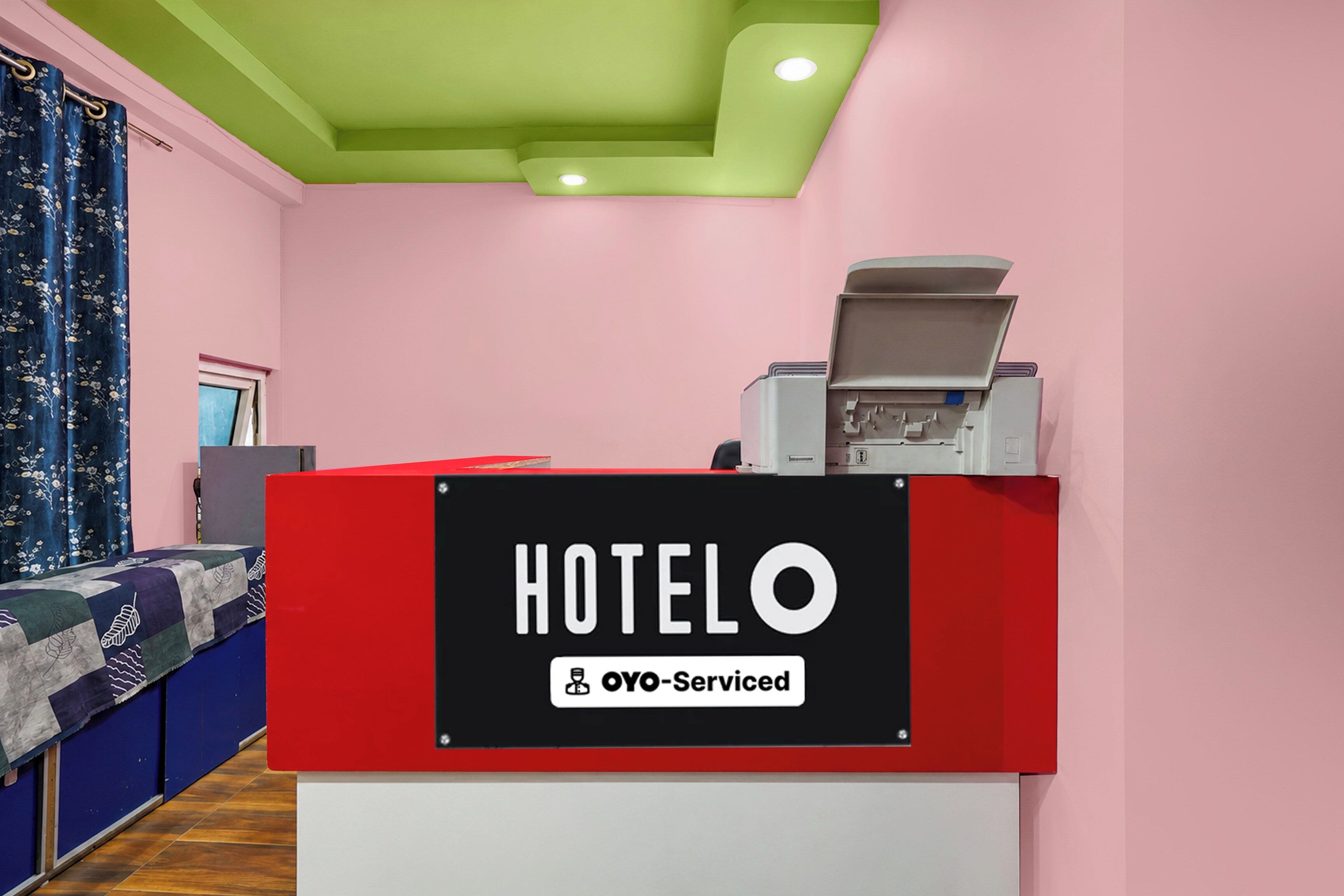 A hotel reception desk with a sign indicating it is OYO-Serviced.