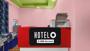 A hotel reception desk with a sign indicating it is OYO-Serviced.