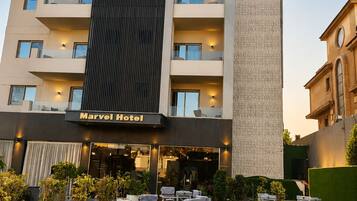 Un hotel con fachada moderna, zona de estar al aire libre y un letrero que dice 'MarvelPyramids View Hotel'.