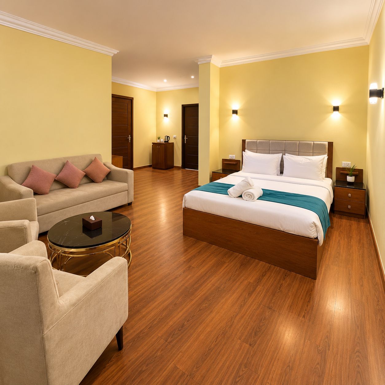 A hotel room with a bed, a sofa, a coffee table, and a nightstand.