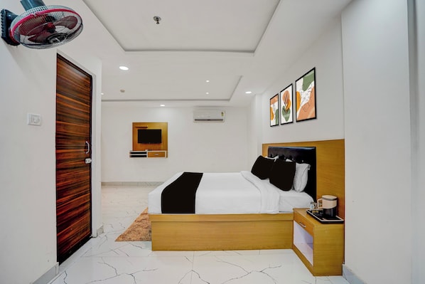 Une chambre à coucher moderne avec un lit, une table de chevet et une œuvre d’art accrochée au mur.
