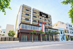 Un immeuble à plusieurs étages portant une enseigne indiquant « TOWNHOUSE OYO – Services hôteliers ».