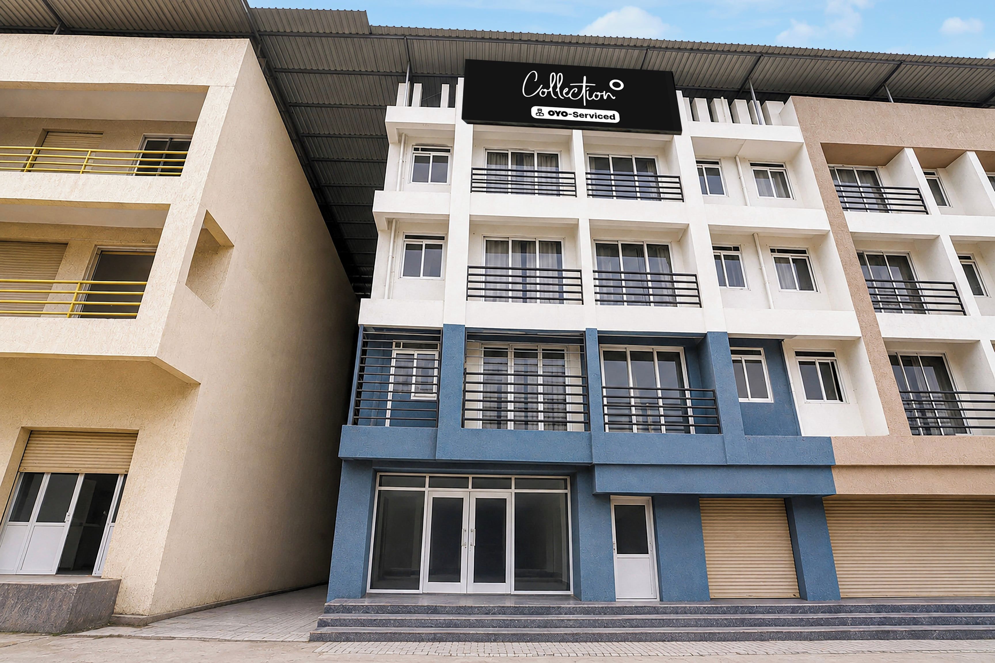 Un edificio de varios pisos con un letrero que dice 'Collection OYO-Serviced'.