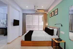 Un dormitorio moderno con cama, mesita de noche y televisión en la pared.