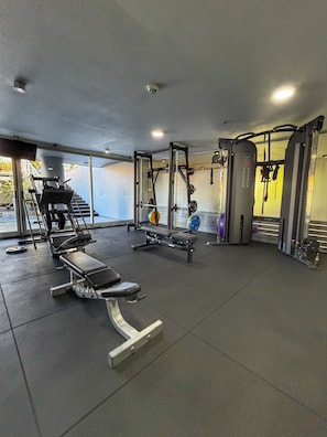 A gym with weightlifting equipment, treadmills, and a bench press area. - Spacious 2-Bedroom Apartment | Tressesenta Tower | Punta del Este (Punta del Este)