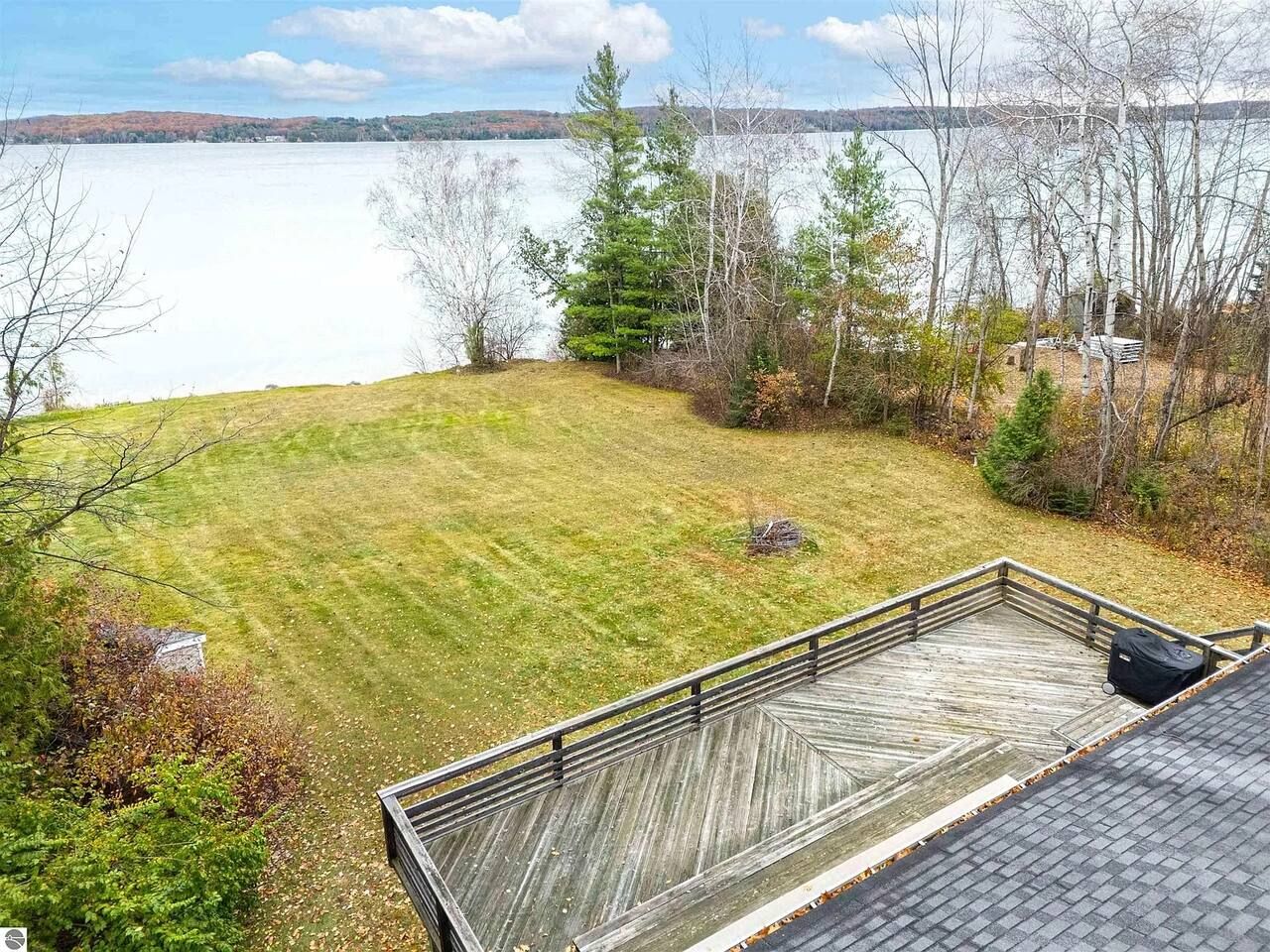 Une terrasse avec vue sur un lac et les arbres environnants.
