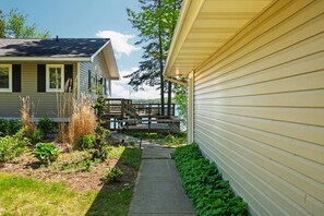 A residential property with a pathway leading to a wooden deck overlooking a body of water. - Elk Lake Waterfront |  Dock, Fire Pit & Beach (Williamsburg)