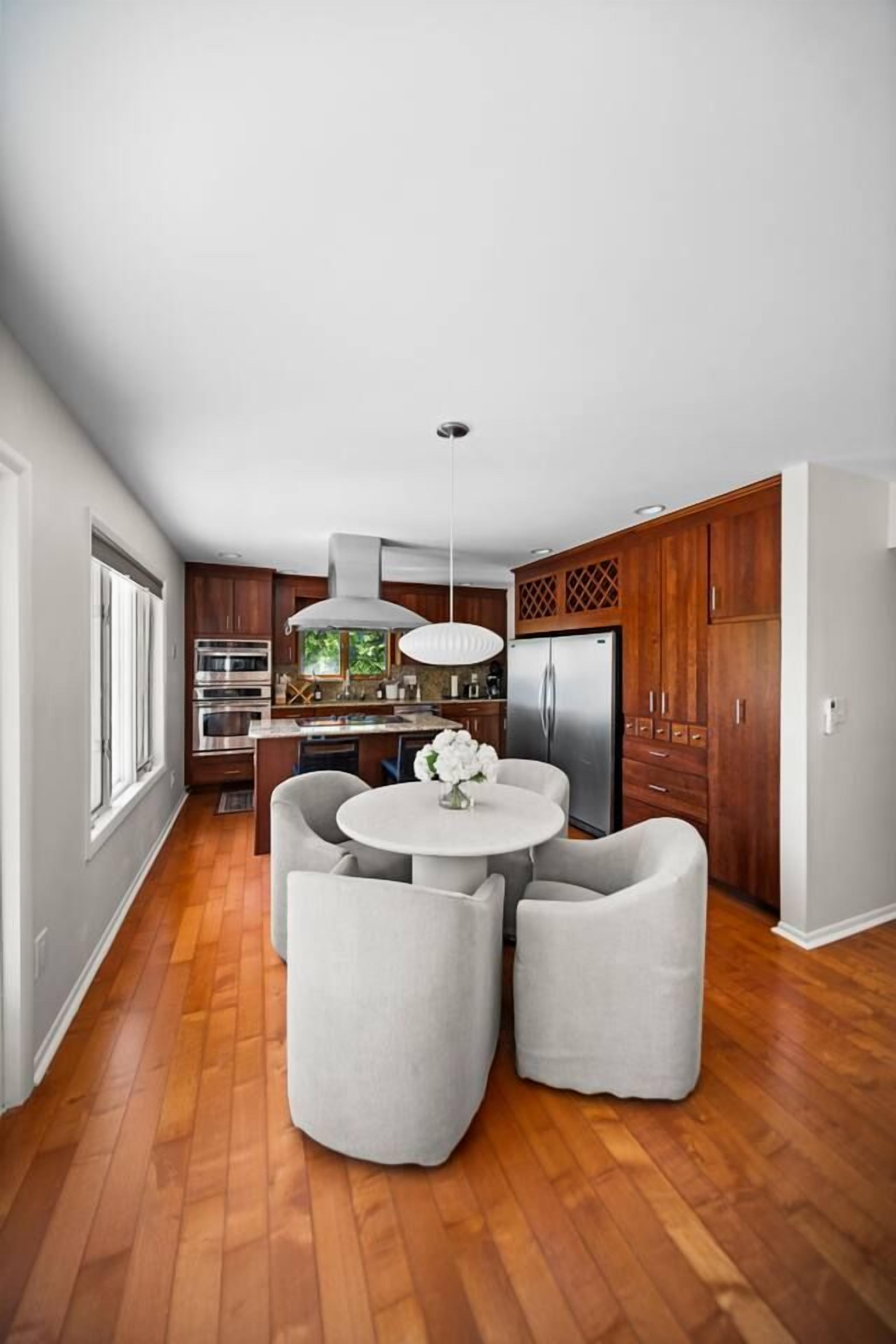 A modern kitchen with wooden cabinets, stainless steel appliances, and a central island with seating.