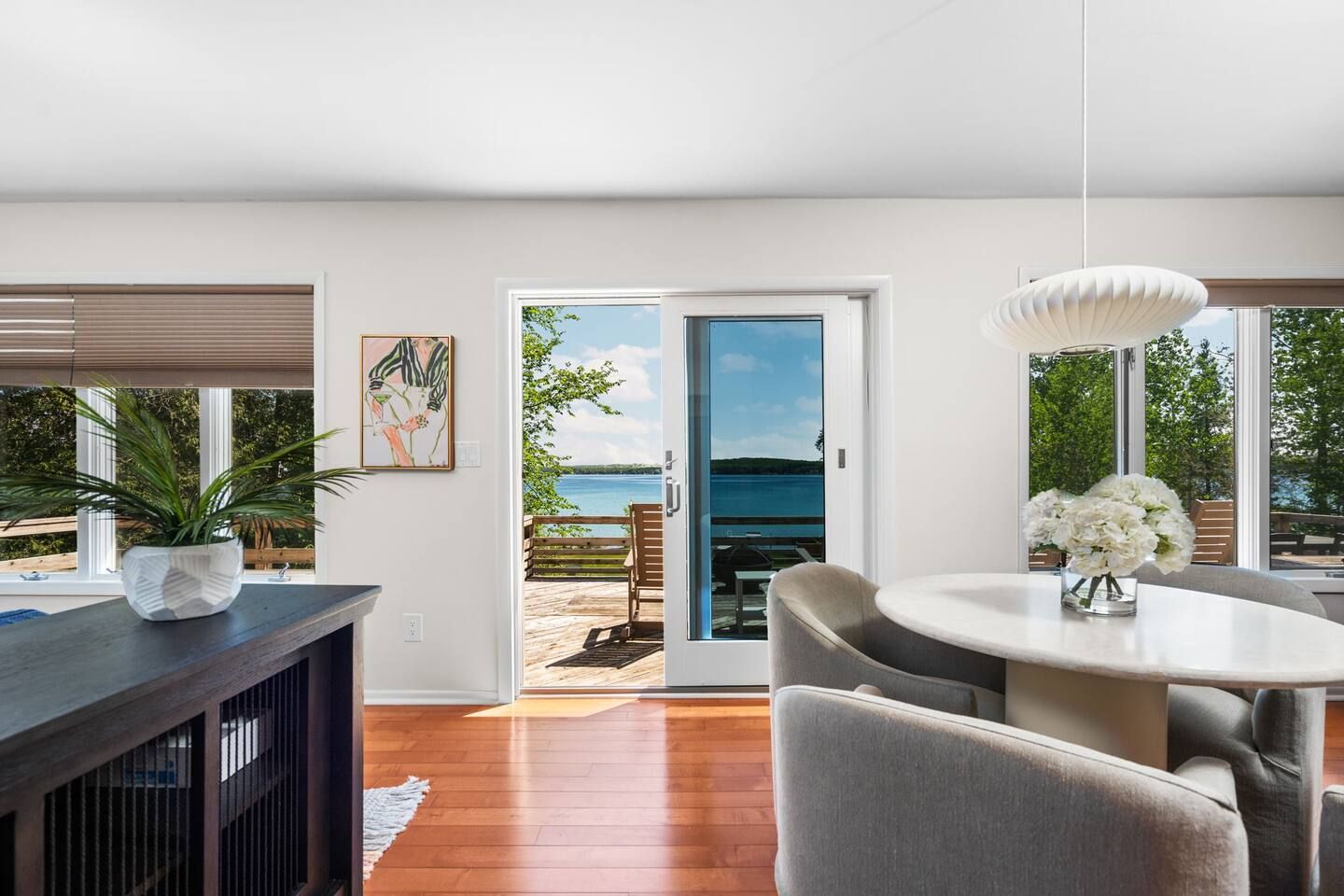 Een modern interieur met een eethoek, uitzicht op de omgeving en een deur naar een terras.