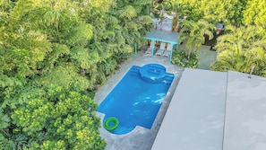 An aerial view of a swimming pool surrounded by lush greenery, with a covered seating area and a basketball hoop. - 5 bedroom/ 3 Bathroom Tropical Resort w/Gym near Pompano Beach and Parks (Pompano Beach)