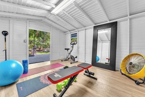 A gym with exercise equipment, a mirror, and a fan. - 5 bedroom/ 3 Bathroom Tropical Resort w/Gym near Pompano Beach and Parks (Pompano Beach)