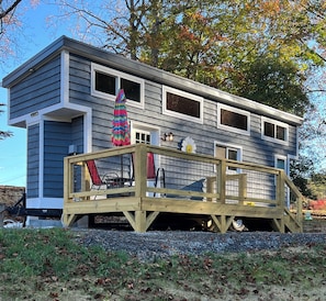 A two-story house with a deck, a colorful umbrella, and a flower decoration.