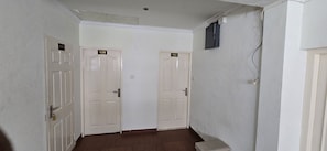 A hallway with two doors labeled 109 and 108, a light switch, and a power outlet on the wall.