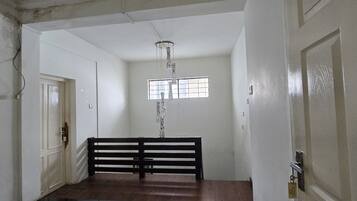 A hallway with a wooden bench, a door, and a window with a grid pattern.