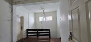 A hallway with a wooden bench, a door, and a window with a grid pattern.