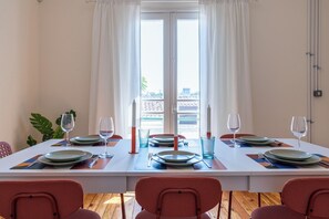 Zona pranzo con tavolo apparecchiato per quattro, comprensivo di piatti, bicchieri e posate.