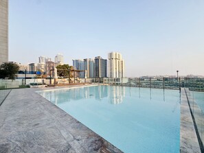 Ein Pool auf dem Dach mit einer Stadtansicht im Hintergrund.