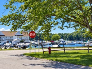 A marina with boats docked, a stop sign, and a building with a balcony.