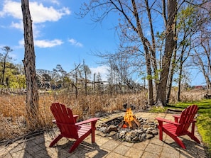 An outdoor seating area with two red chairs and a fire pit.