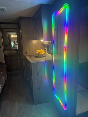 Una cocina moderna con refrigerador integrado, una pequeña encimera y un jarrón con flores.