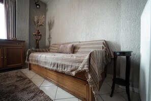 A bedroom with a wooden bed, a small table, a cabinet, and a decorative vase. - Kokkovos Guesthouse Arachova by ΜΡS (Arachova)