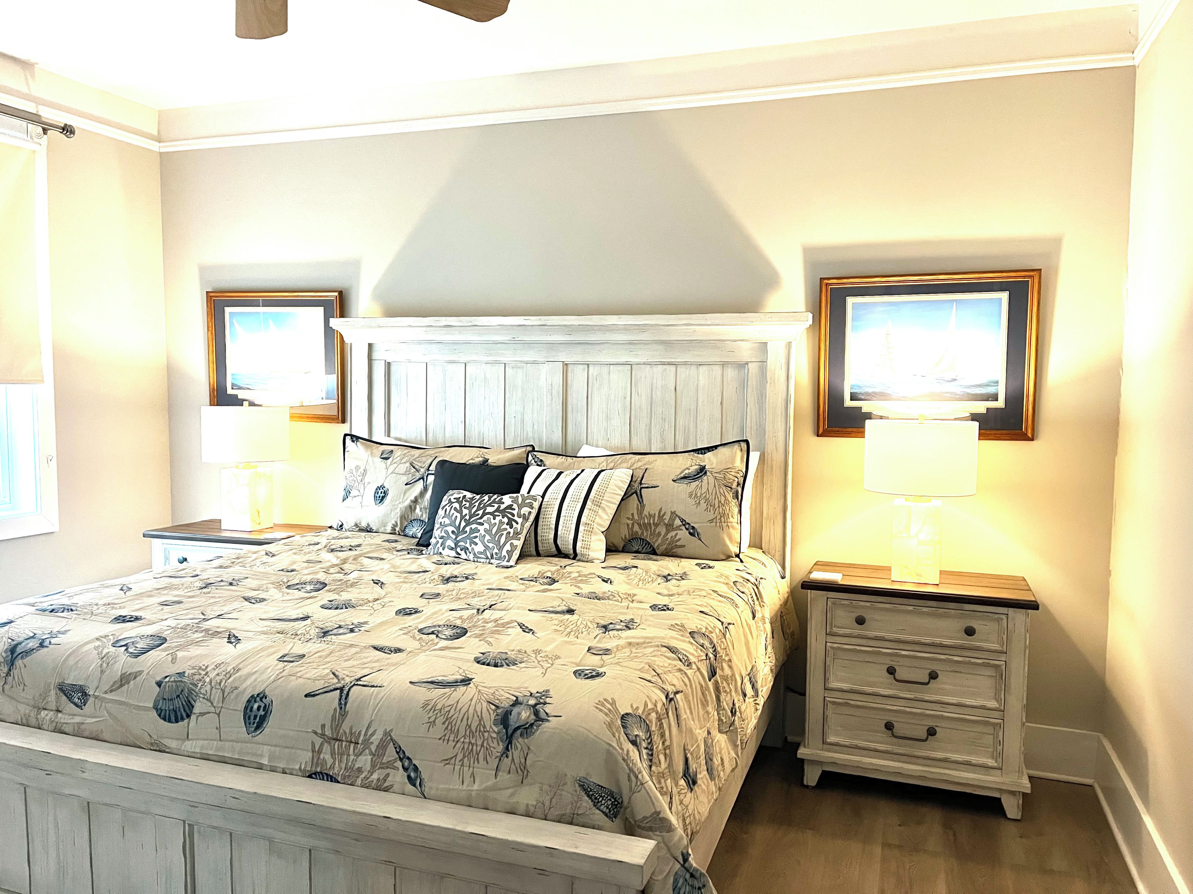 A bedroom with a bed, nightstands, a headboard, and wall-mounted lamps.