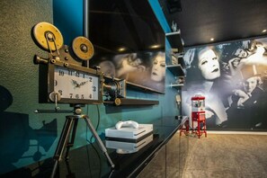 A room with a vintage clock, a projector, and a red telephone booth. - 7BR Kissimmee home | Pool, cinema, games (Kissimmee)
