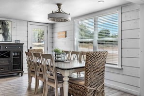 A dining area with a table, chairs, and a ceiling fan. - NEW! Fall Hill Country | Hot Tub, Pool, Sleeps 11 (Dripping Springs)