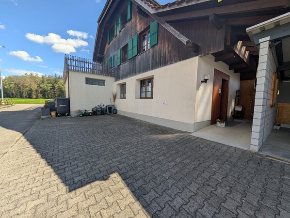 A two-story building with a paved driveway and a fenced area. - Waldblick Apartment, Quiet, Emmental, Solothurn & Bern (Kernenried)