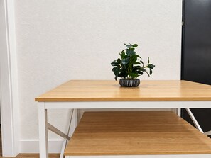 Ein Holztisch mit einer Topfpflanze in der Mitte.