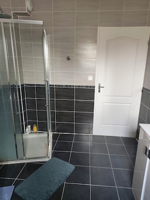 A bathroom with a shower, a toilet, and a sink.