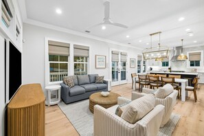 Uma sala de estar moderna com sofá, mesa de centro e área de jantar com cadeiras.