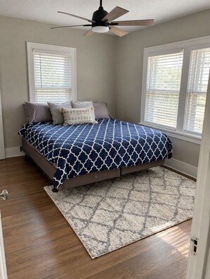 A bedroom with a bed, a ceiling fan, and a window with blinds. - Serenity on Sherwood | Old Town, Dogs Welcome (Fort Collins)