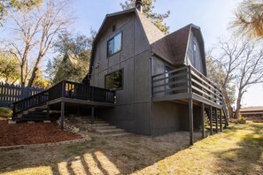 A modern two-story house with a balcony and a staircase leading to the upper level. - Luxury Cabin with EV Tesla Charger & Hot Tub! (Idyllwild-Pine Cove)