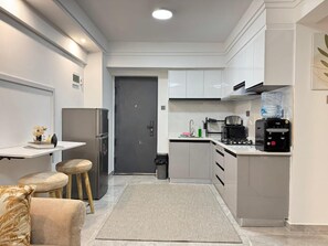 A modern kitchen with a refrigerator, stove, and coffee maker. - 2bedroom polaris Residency kilimani (Nairobi)