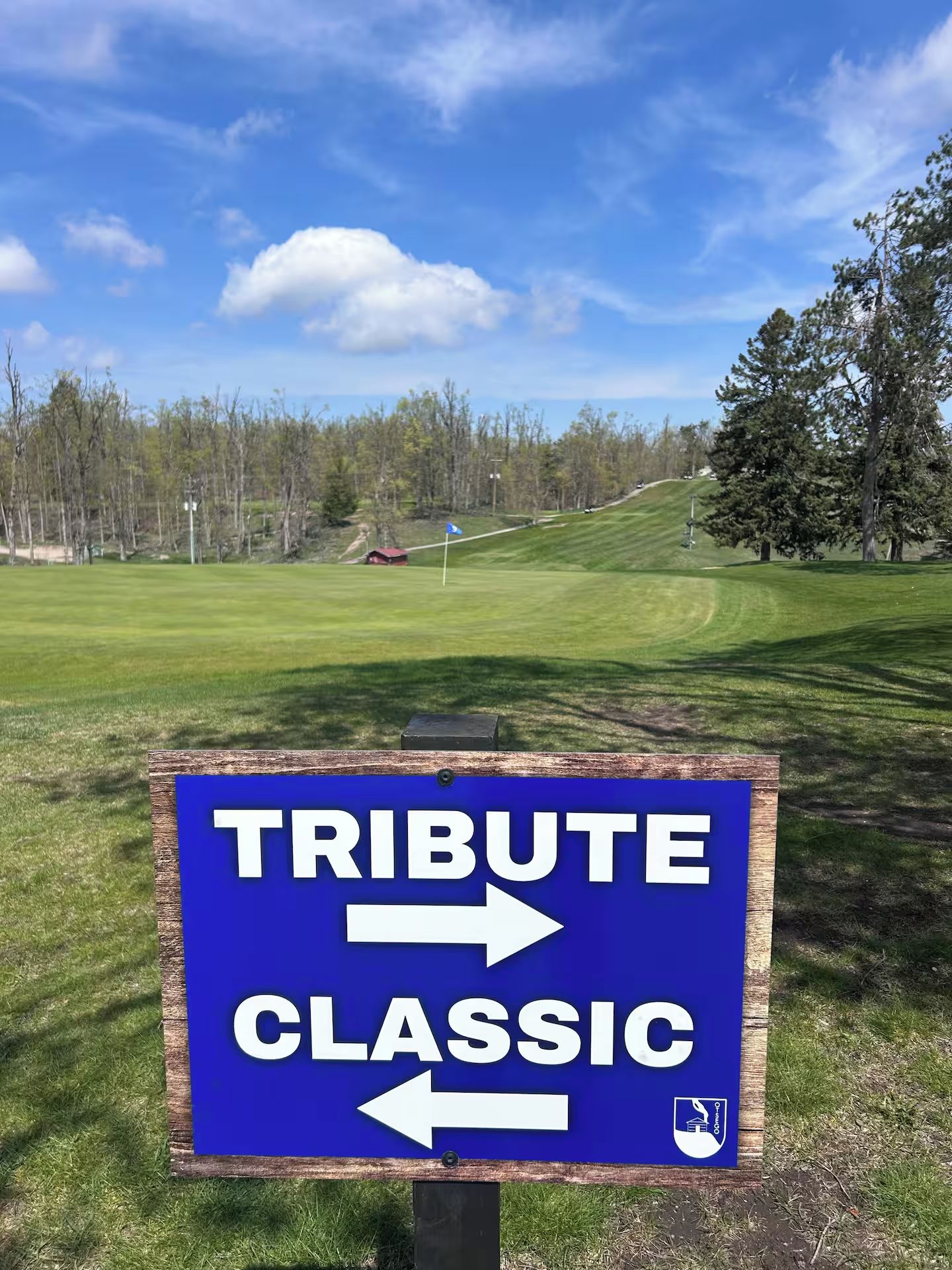 Un panneau indiquant la direction de « TRIBUTE CLASSIC » sur un terrain de golf.