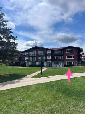 Lodge-style condo with balconies, green lawns, and easy path access
